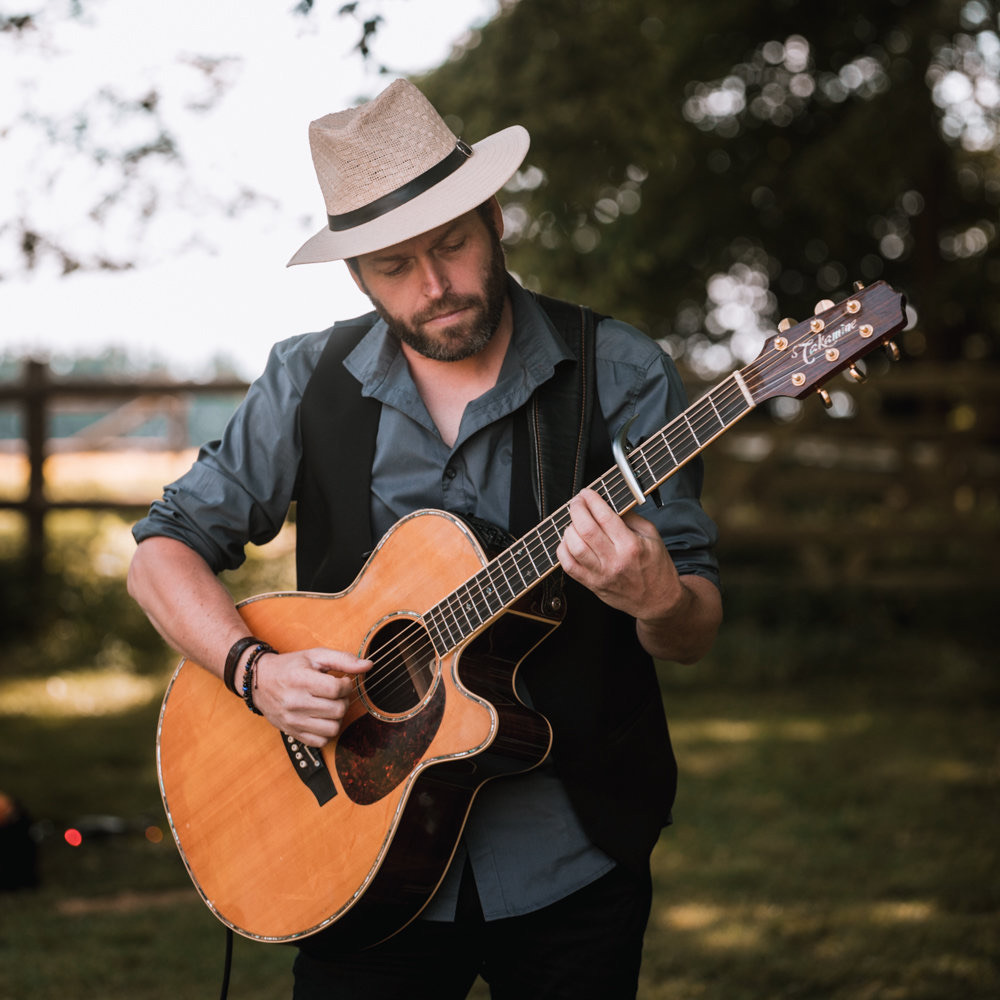 Rom au chapeau avec sa guitare, en extérieur